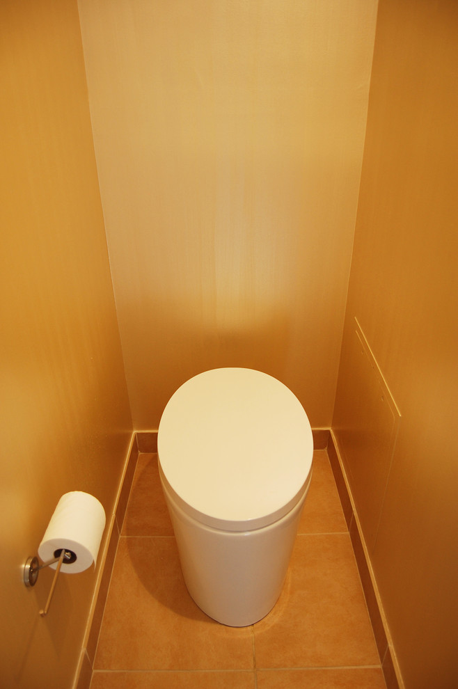 Bild på ett funkis toalett, med en toalettstol med hel cisternkåpa, orange kakel, keramikplattor och klinkergolv i keramik