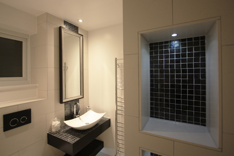 Small contemporary shower room bathroom in London with freestanding cabinets, black cabinets, a walk-in shower, a one-piece toilet, black tiles, glass tiles, white walls, porcelain flooring and tiled worktops.