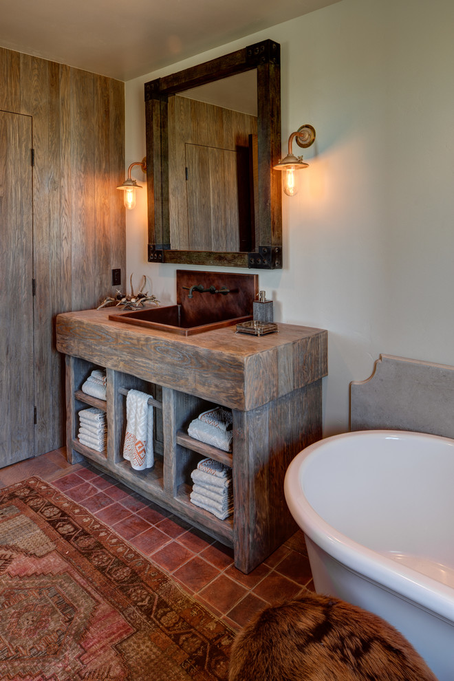 Exempel på ett mellanstort lantligt badrum, med öppna hyllor, skåp i ljust trä, ett fristående badkar, en toalettstol med separat cisternkåpa, ett väggmonterat handfat och träbänkskiva