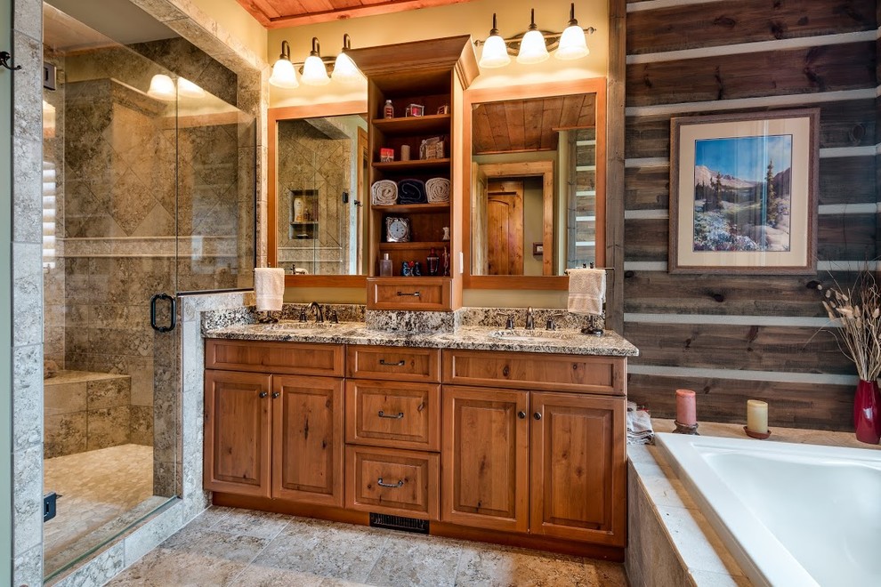 This is an example of a large rustic ensuite bathroom in Other with a submerged sink, recessed-panel cabinets, light wood cabinets, granite worktops, a freestanding bath, an alcove shower, beige tiles, ceramic tiles and porcelain flooring.