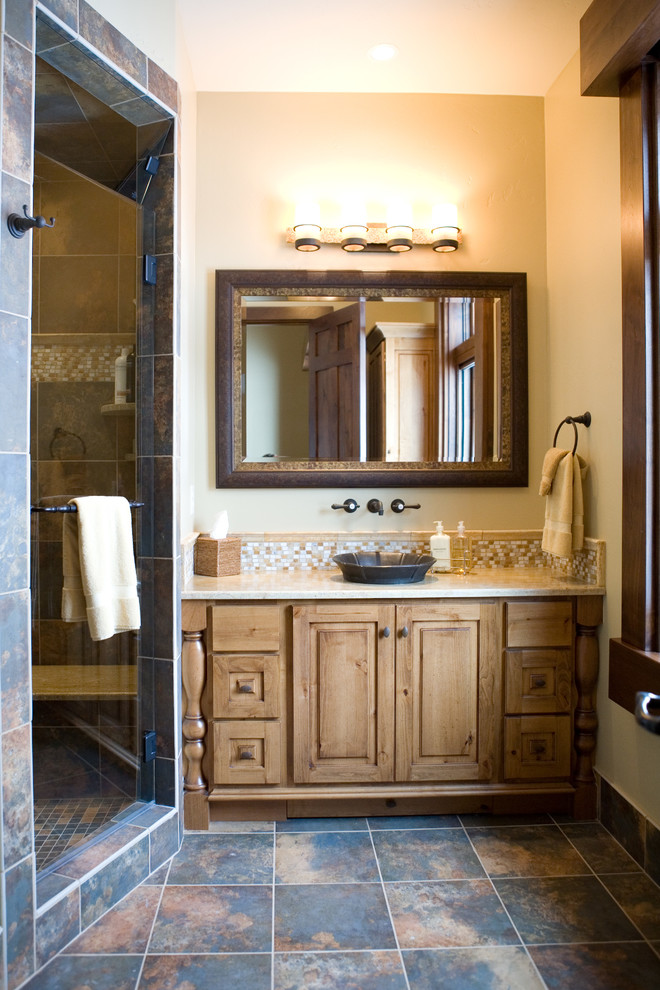 Inspiration for a large rustic bathroom in Salt Lake City with a vessel sink, medium wood cabinets, an alcove shower, beige walls, engineered stone worktops, multi-coloured tiles, slate flooring, slate tiles and raised-panel cabinets.