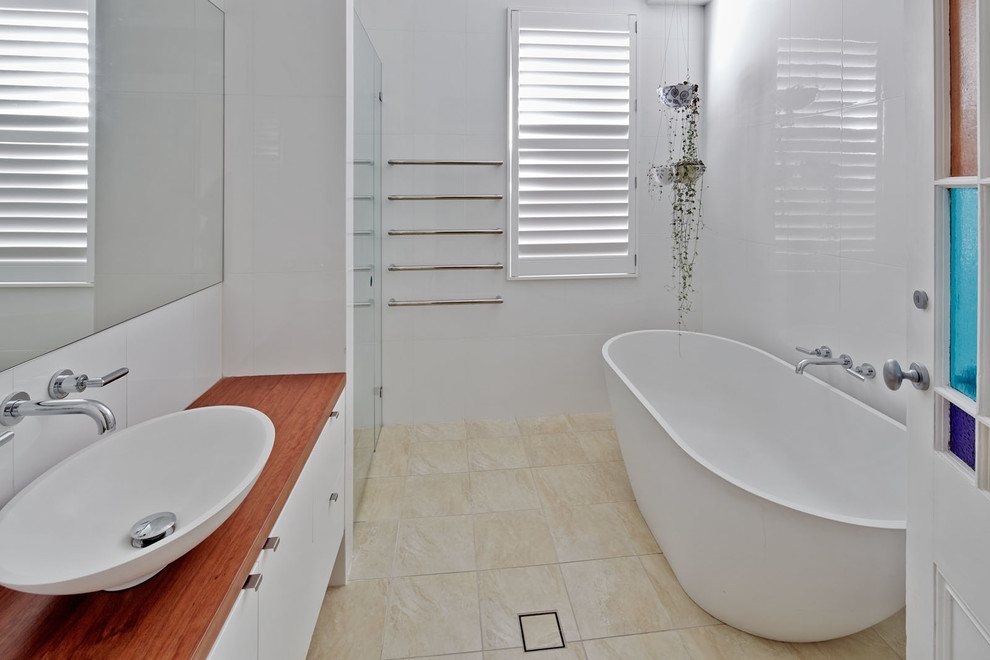 Foto di una stanza da bagno contemporanea con vasca freestanding, doccia a filo pavimento, piastrelle beige e pareti bianche