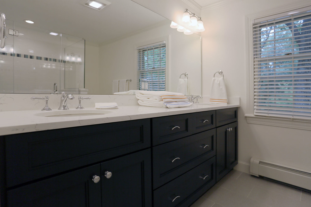 This is an example of a traditional family bathroom in Boston with flat-panel cabinets, blue cabinets, a corner shower, a one-piece toilet, blue tiles, porcelain tiles, white walls, porcelain flooring, a submerged sink and engineered stone worktops.