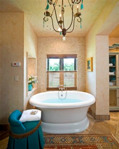 This is an example of a medium sized rustic bathroom in Houston with glass-front cabinets, distressed cabinets, a freestanding bath, a wall mounted toilet, black tiles, stone tiles, beige walls and terrazzo flooring.