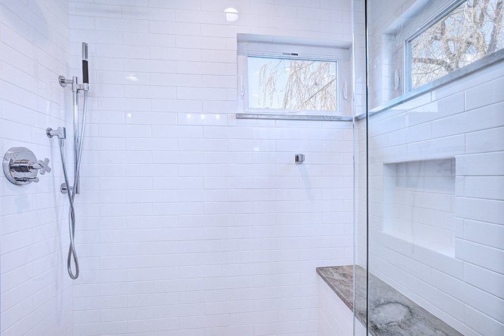 Свежая идея для дизайна: главная ванная комната среднего размера в стиле неоклассика (современная классика) с белыми фасадами, белой плиткой, мраморным полом, душем с распашными дверями, фасадами с утопленной филенкой, угловым душем, унитазом-моноблоком, мраморной плиткой, белыми стенами, врезной раковиной, столешницей из известняка, белым полом и серой столешницей - отличное фото интерьера