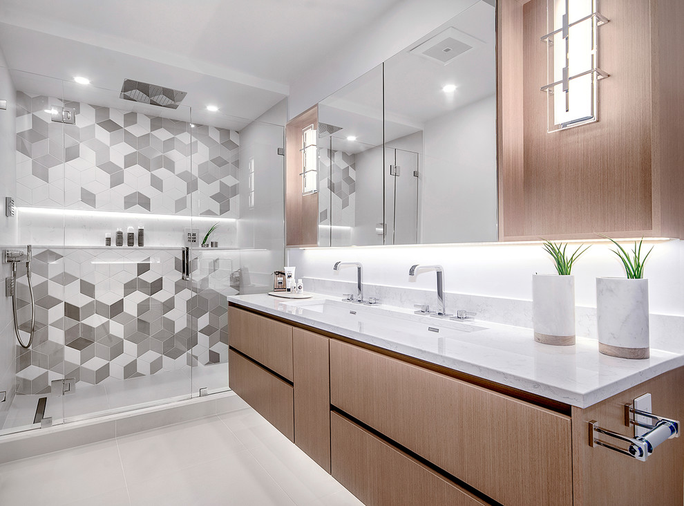 Photo of a medium sized modern bathroom in Vancouver with flat-panel cabinets, light wood cabinets, an alcove shower, grey tiles, porcelain tiles, white walls, porcelain flooring, an integrated sink, engineered stone worktops, grey floors, a hinged door, grey worktops and a freestanding bath.