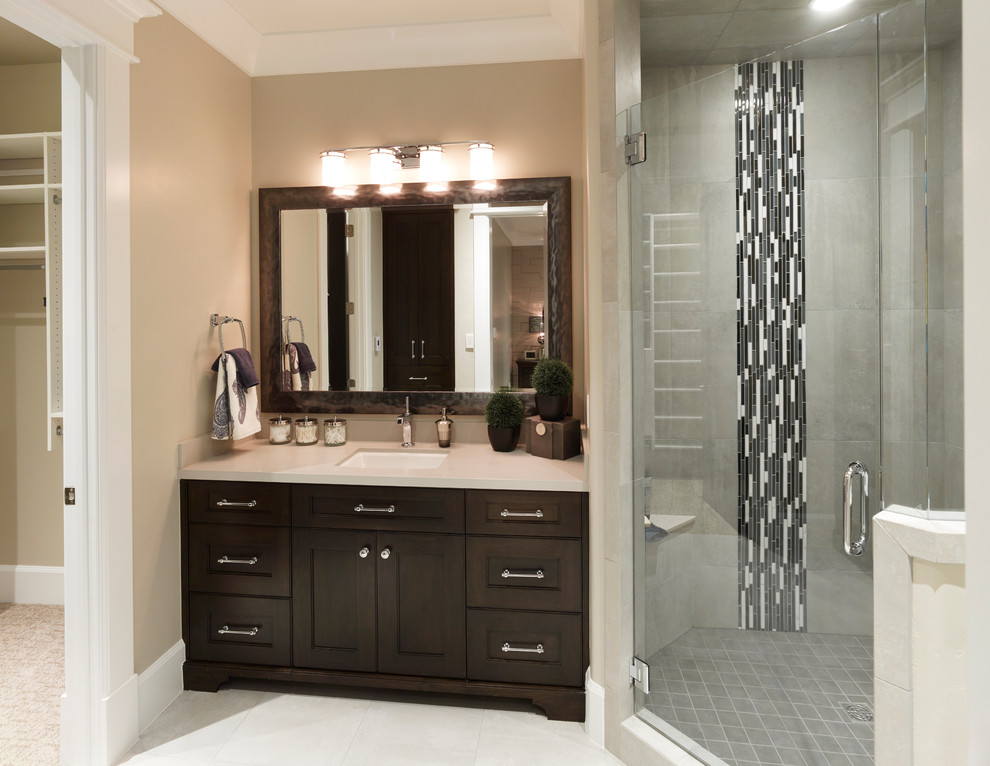 Example of a mid-sized classic white tile and ceramic tile ceramic tile alcove shower design in Salt Lake City with an undermount sink, recessed-panel cabinets, dark wood cabinets, solid surface countertops, a two-piece toilet and beige walls