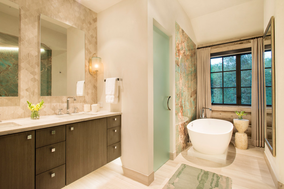 Imagen de cuarto de baño principal rústico con armarios con paneles lisos, puertas de armario de madera en tonos medios, bañera exenta, paredes beige, lavabo bajoencimera y suelo beige
