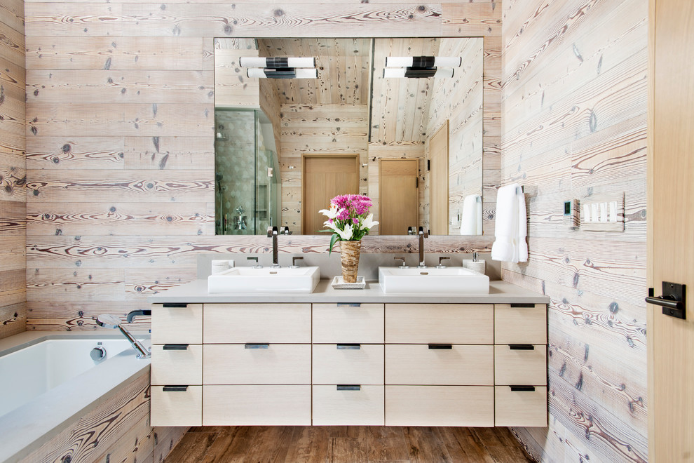Bild på ett rustikt badrum, med släta luckor, skåp i ljust trä, ett undermonterat badkar och mellanmörkt trägolv