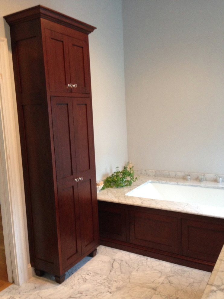 Idée de décoration pour une salle de bain principale tradition en bois foncé de taille moyenne avec un placard avec porte à panneau encastré, un bain bouillonnant, un carrelage gris, un mur vert, un sol en marbre et un plan de toilette en marbre.