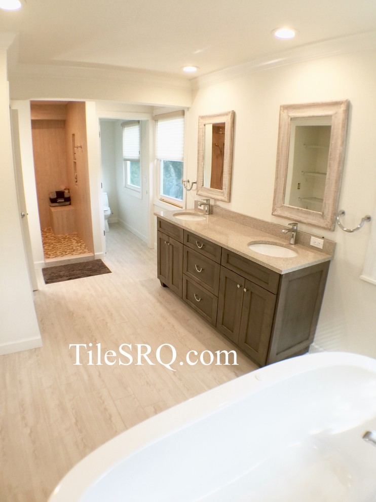 Inspiration for a large coastal master gray tile and porcelain tile porcelain tile bathroom remodel in Tampa with an undermount sink, furniture-like cabinets, distressed cabinets, quartz countertops, a two-piece toilet and beige walls