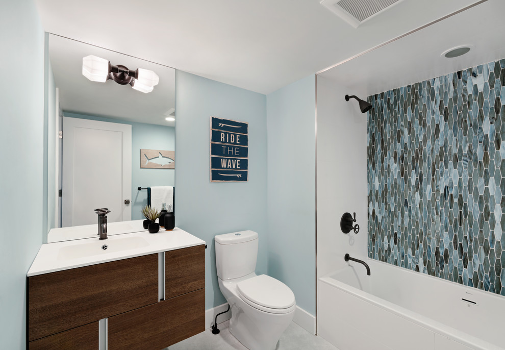 Inspiration för ett 60 tals badrum för barn, med ett badkar i en alkov, en dusch i en alkov, en toalettstol med separat cisternkåpa, blå väggar, ett väggmonterat handfat och med dusch som är öppen