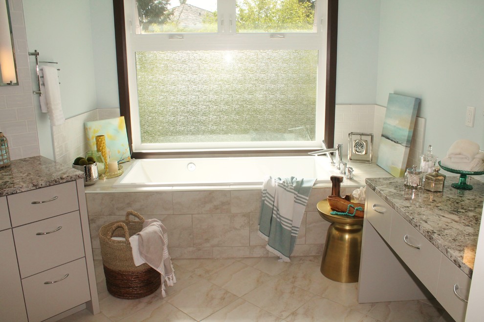 Foto på ett mellanstort funkis en-suite badrum, med släta luckor, grå skåp, ett platsbyggt badkar, vit kakel, keramikplattor, blå väggar, klinkergolv i porslin och granitbänkskiva