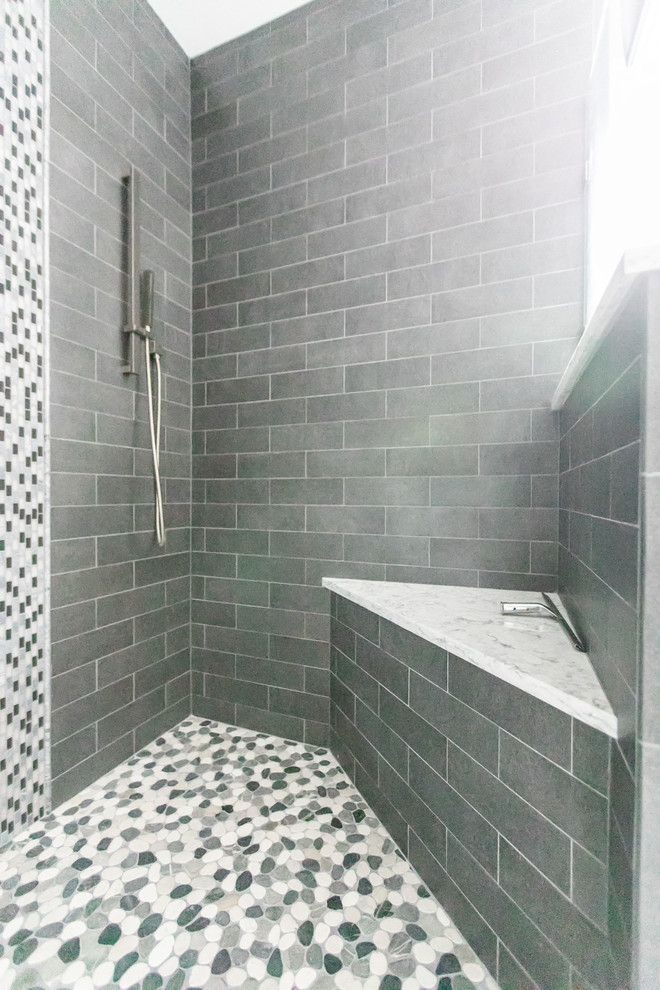 Photo of a medium sized contemporary ensuite bathroom in Baltimore with flat-panel cabinets, grey cabinets, a freestanding bath, a corner shower, grey tiles, porcelain tiles, grey walls, porcelain flooring, a submerged sink, engineered stone worktops, grey floors, a hinged door and white worktops.