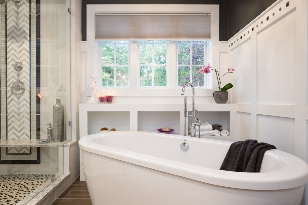 Inspiration for a large traditional ensuite bathroom in Manchester with recessed-panel cabinets, white cabinets, a freestanding bath, a walk-in shower, a one-piece toilet, white tiles, stone tiles, black walls, dark hardwood flooring, a submerged sink and engineered stone worktops.