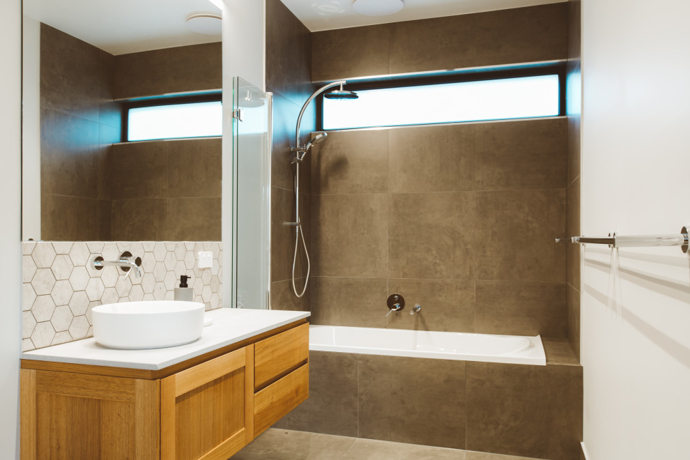 Mid-sized trendy 3/4 gray tile porcelain tile, gray floor and single-sink bathroom photo in Hobart with shaker cabinets, medium tone wood cabinets, white walls, a vessel sink, a hinged shower door, white countertops and a floating vanity