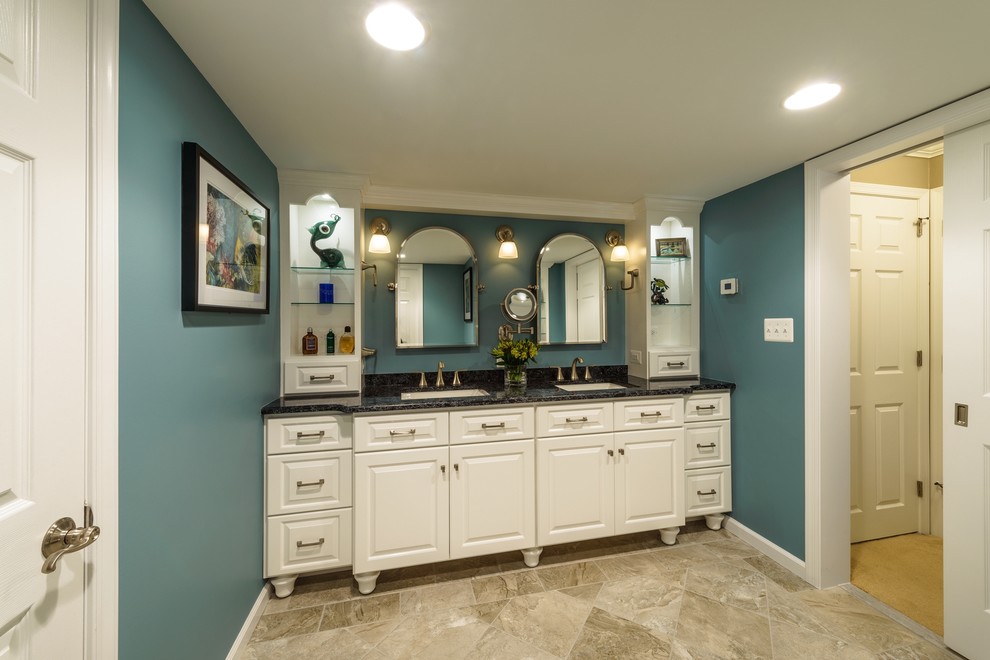 Inredning av ett klassiskt stort en-suite badrum, med ett undermonterad handfat, luckor med profilerade fronter, vita skåp, granitbänkskiva, en hörndusch, en toalettstol med separat cisternkåpa, vit kakel, keramikplattor, blå väggar och klinkergolv i keramik