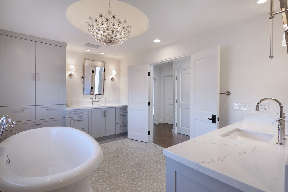 Inspiration pour une salle de bain principale rustique avec un placard à porte shaker, des portes de placard grises, une baignoire indépendante, un mur blanc, carreaux de ciment au sol, un lavabo encastré, un plan de toilette en quartz modifié et un sol gris.