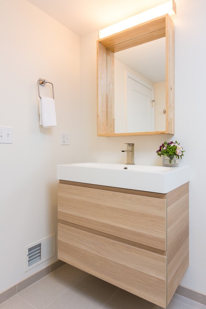 Réalisation d'une petite salle de bain minimaliste en bois clair avec un placard à porte plane, un carrelage bleu, un carrelage en pâte de verre, un mur blanc, un sol en carrelage de porcelaine, un lavabo intégré, un plan de toilette en quartz modifié et un sol marron.