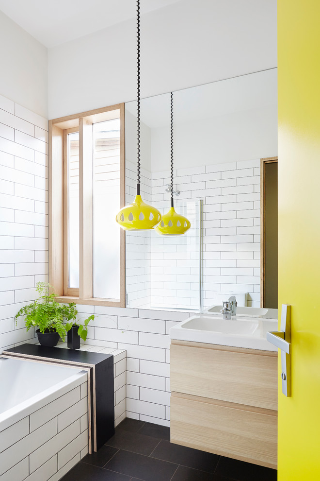 Design ideas for a small contemporary family bathroom in Melbourne with light wood cabinets, a built-in bath, a shower/bath combination, a one-piece toilet, white tiles, metro tiles, white walls and slate flooring.