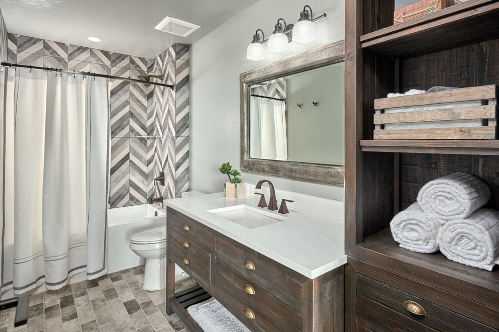Tub/shower combo - mid-sized craftsman kids' gray tile gray floor tub/shower combo idea in Portland with shaker cabinets, medium tone wood cabinets, a one-piece toilet, gray walls, an undermount sink and a hinged shower door