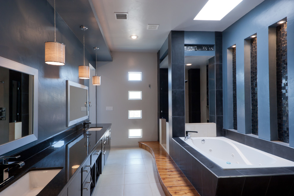 Large modern ensuite bathroom in Austin with flat-panel cabinets, black cabinets, a built-in bath, an alcove shower, black tiles, blue tiles, mosaic tiles, multi-coloured walls, porcelain flooring, a trough sink, solid surface worktops, white floors and an open shower.