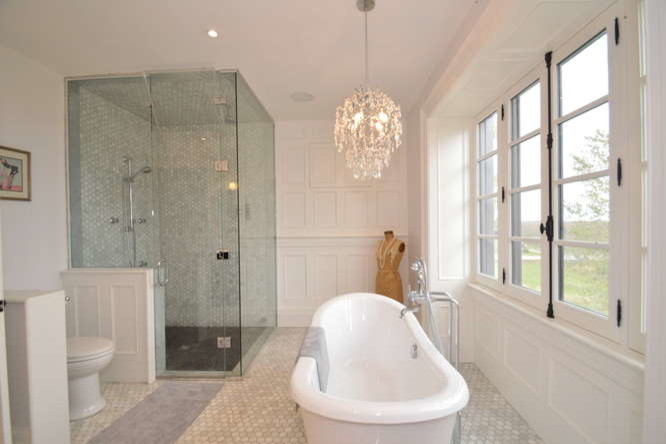 Lantlig inredning av ett stort en-suite badrum, med ett badkar med tassar, en hörndusch, vit kakel, stenkakel, vita väggar och marmorgolv