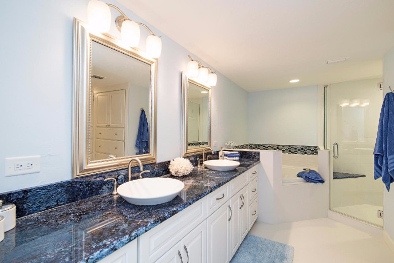 На фото: главная ванная комната среднего размера в стиле неоклассика (современная классика) с фасадами с выступающей филенкой, белыми фасадами, угловой ванной, угловым душем, синей плиткой, стеклянной плиткой, белыми стенами, настольной раковиной, столешницей из искусственного кварца, белым полом, душем с распашными дверями и синей столешницей