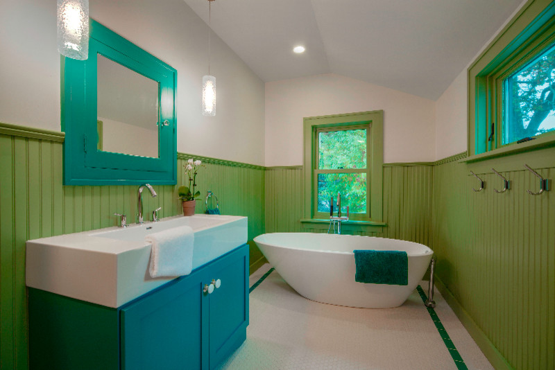 Réalisation d'une salle de bain principale tradition de taille moyenne avec un placard à porte shaker, des portes de placard bleues, une baignoire indépendante, un mur blanc, une grande vasque et un sol blanc.