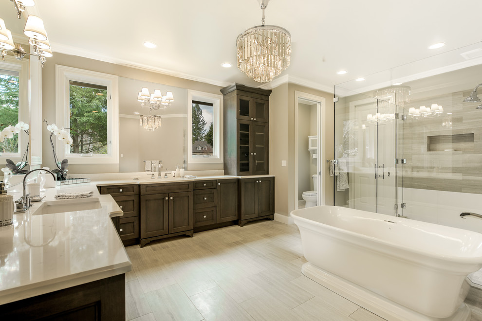Example of a large transitional master beige tile and porcelain tile porcelain tile and beige floor bathroom design in Seattle with beaded inset cabinets, dark wood cabinets, a two-piece toilet, beige walls, an undermount sink, quartz countertops, a hinged shower door and white countertops