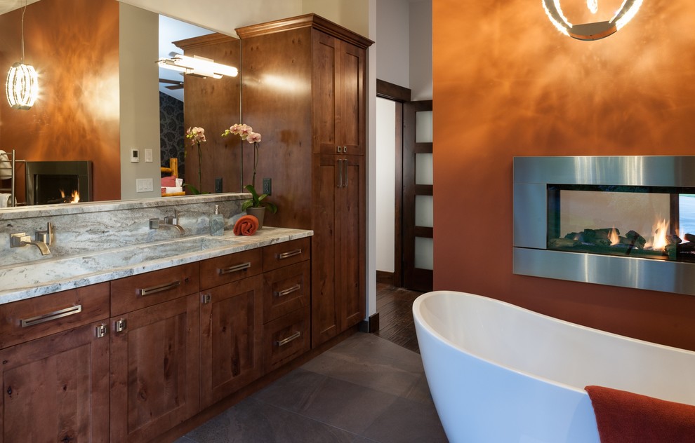 Immagine di una grande stanza da bagno padronale con ante in legno bruno, vasca freestanding, piastrelle grigie e pareti arancioni