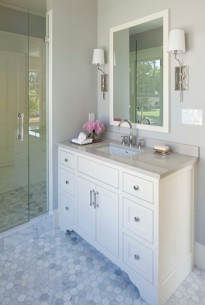 Idées déco pour une douche en alcôve classique avec un lavabo encastré, un placard avec porte à panneau encastré et des portes de placard blanches.