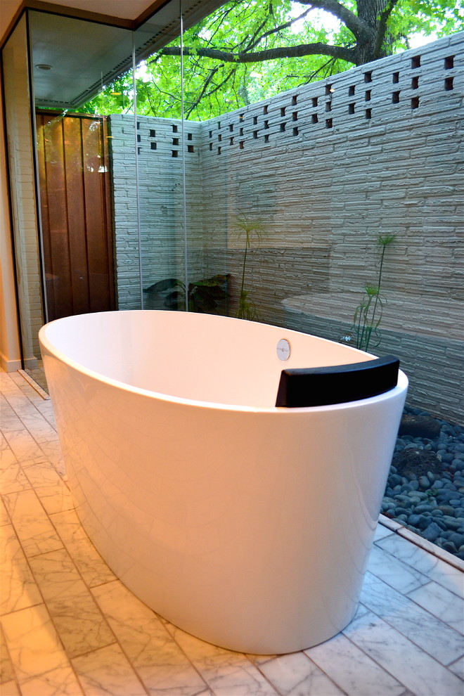 Modernes Badezimmer mit freistehender Badewanne, Steinwänden und Pflanzen in Oklahoma City