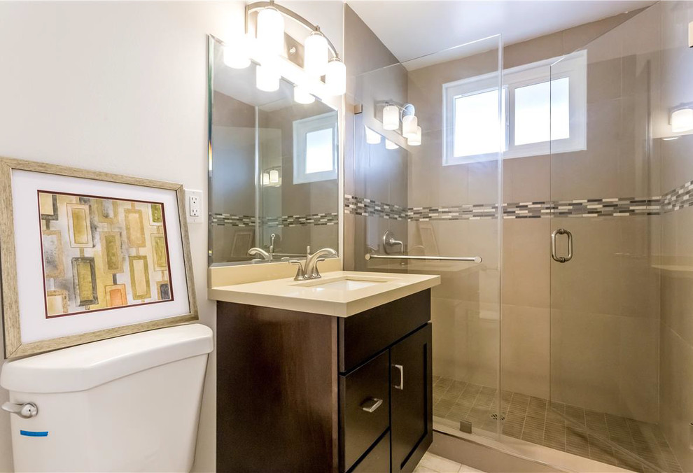 Mid-sized transitional 3/4 beige tile and ceramic tile limestone floor double shower photo in Los Angeles with flat-panel cabinets, dark wood cabinets, a two-piece toilet, beige walls, an undermount sink and quartz countertops