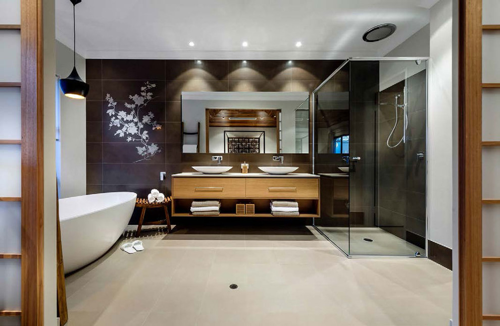 Inspiration for a medium sized contemporary ensuite bathroom in Los Angeles with flat-panel cabinets, light wood cabinets, a freestanding bath, a corner shower, black tiles, stone tiles, white walls, concrete flooring, a vessel sink, solid surface worktops, beige floors and a hinged door.