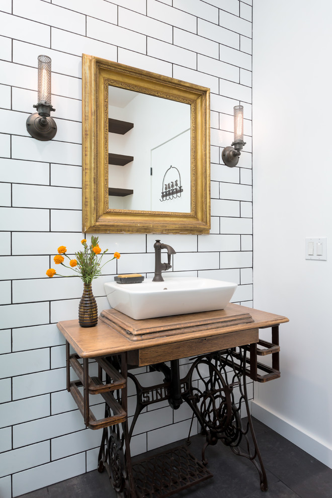 Idée de décoration pour une petite salle de bain urbaine avec un carrelage blanc, des carreaux de céramique, un mur blanc, un sol en carrelage de porcelaine, une vasque, un plan de toilette en bois, un sol noir et un plan de toilette marron.