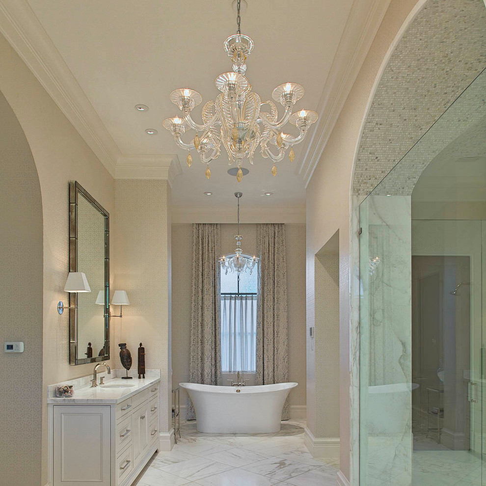 Foto på ett medelhavsstil badrum, med ett fristående badkar, en kantlös dusch och marmorgolv
