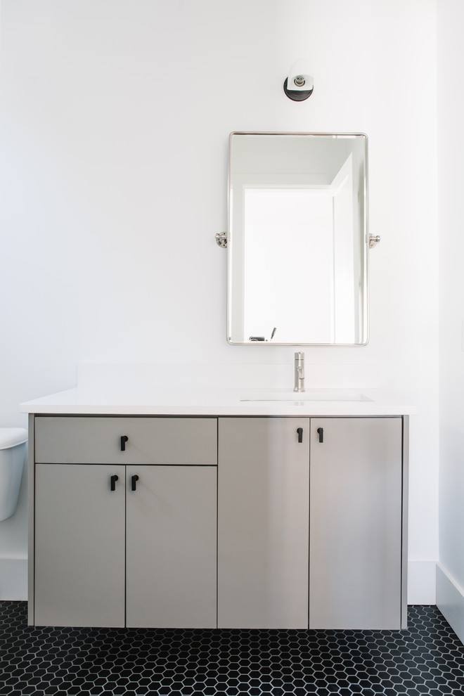 На фото: ванная комната среднего размера в стиле модернизм с серыми фасадами, белой плиткой, каменной плиткой, белыми стенами, полом из керамической плитки, врезной раковиной и черным полом