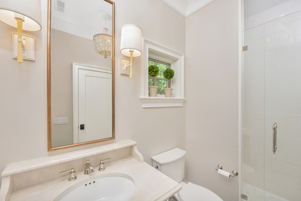 Foto på ett mellanstort beige badrum med dusch, med en hörndusch, en toalettstol med hel cisternkåpa, vit kakel, keramikplattor, beige väggar, ett nedsänkt handfat, granitbänkskiva och dusch med gångjärnsdörr