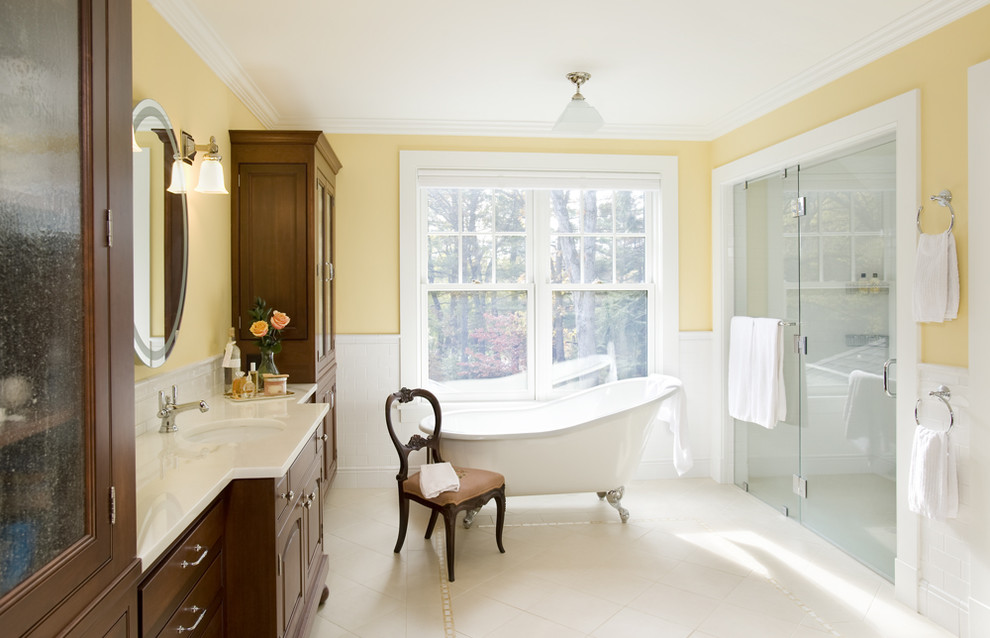 Cette photo montre une salle de bain victorienne avec une baignoire sur pieds et un mur jaune.