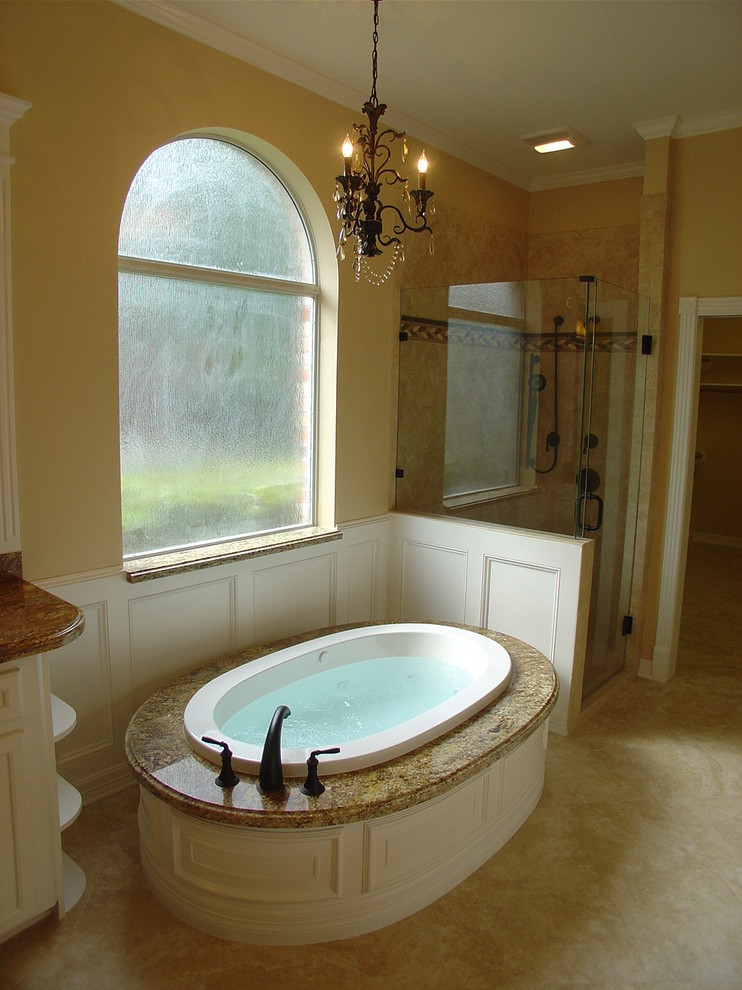 Ispirazione per una grande stanza da bagno padronale classica con ante bianche, vasca freestanding, doccia ad angolo, pareti beige e pavimento in pietra calcarea
