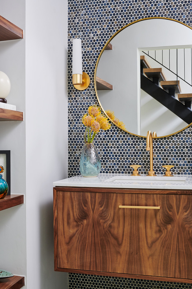 Idée de décoration pour une salle de bain design en bois clair de taille moyenne avec un placard à porte plane, WC à poser, mosaïque, un mur bleu, carreaux de ciment au sol, un lavabo encastré, un plan de toilette en marbre, un sol bleu et un plan de toilette blanc.