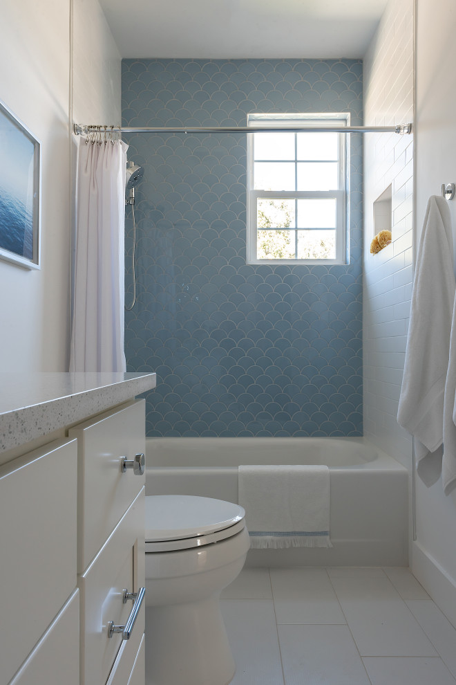 На фото: маленькая детская ванная комната с фасадами в стиле шейкер, белыми фасадами, ванной в нише, душем над ванной, унитазом-моноблоком, синей плиткой, керамической плиткой, белыми стенами, полом из керамической плитки, врезной раковиной, столешницей из искусственного кварца, серым полом, шторкой для ванной, серой столешницей, нишей, тумбой под одну раковину и встроенной тумбой для на участке и в саду с