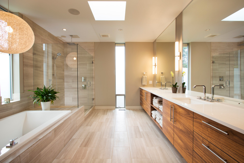 Cette image montre une salle de bain design en bois brun avec un lavabo encastré, un placard à porte plane, une baignoire posée, une douche d'angle, un carrelage beige, un mur beige et un sol beige.