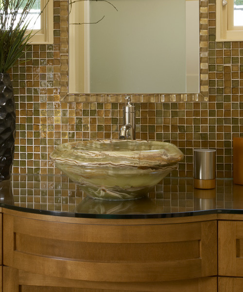 Cette image montre une salle d'eau traditionnelle en bois clair de taille moyenne avec une vasque, un placard à porte shaker, un plan de toilette en granite, un carrelage marron et un carrelage en pâte de verre.