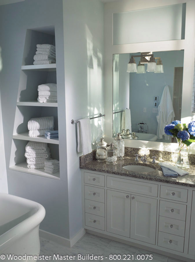 Cette photo montre une salle de bain principale chic de taille moyenne avec un placard avec porte à panneau encastré, des portes de placard blanches, une baignoire indépendante, un carrelage multicolore, un mur bleu, un sol en marbre et un plan de toilette en marbre.