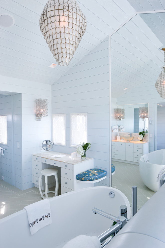 Small beach style master travertine floor freestanding bathtub photo in Boston with flat-panel cabinets, white cabinets, onyx countertops and blue walls