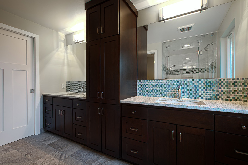 Immagine di una stanza da bagno classica di medie dimensioni con ante in stile shaker, ante in legno bruno, WC a due pezzi, piastrelle blu, piastrelle di vetro, pareti bianche, pavimento in travertino, lavabo sottopiano e top in vetro riciclato