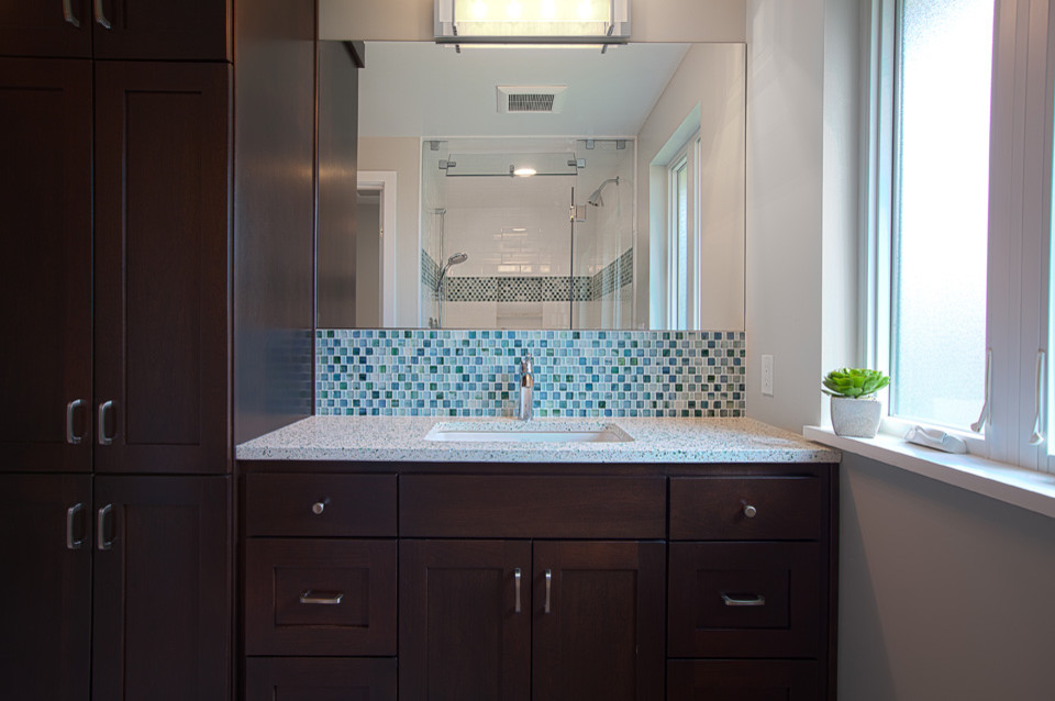 Idee per una stanza da bagno classica di medie dimensioni con lavabo sottopiano, ante in stile shaker, ante in legno bruno, top in vetro riciclato, WC monopezzo, piastrelle blu, piastrelle di vetro, pareti beige e pavimento in gres porcellanato