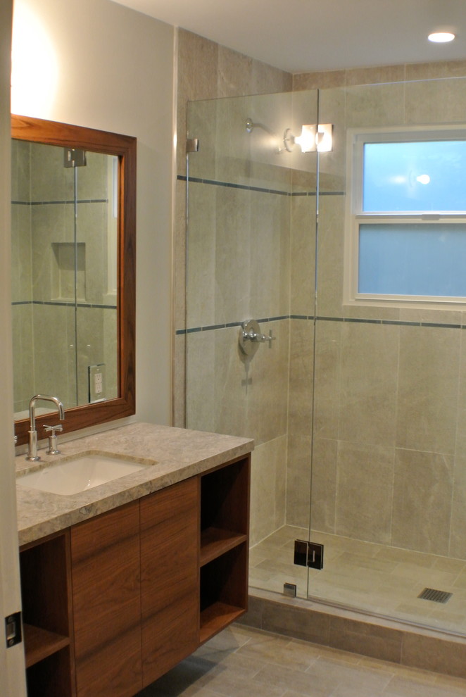 Cette image montre une salle de bain design avec un lavabo encastré, une baignoire encastrée, un combiné douche/baignoire, WC séparés, un placard en trompe-l'oeil, des portes de placard marrons, un plan de toilette en marbre et un carrelage gris.
